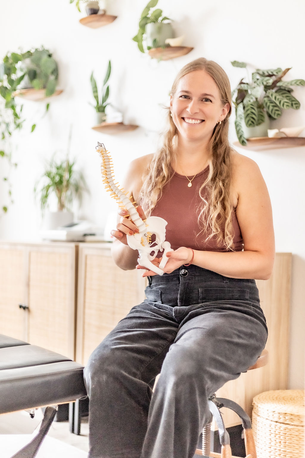 Dr. Laura Barnum holding a spine model in her clinic